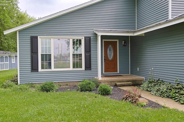 view of exterior entry with a yard