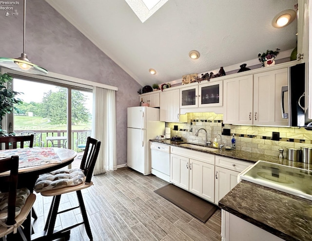 kitchen featuring white cabinets, a skylight, decorative light fixtures, and white appliances