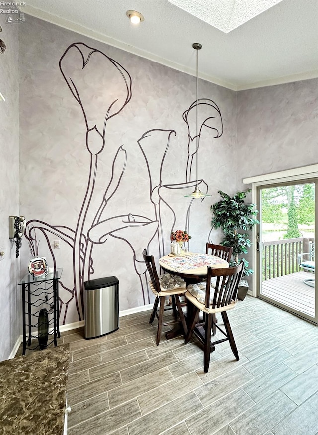 dining area featuring a skylight, a textured ceiling, and crown molding