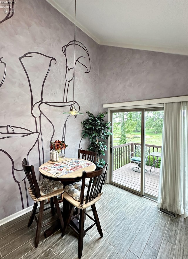 dining area with vaulted ceiling, hardwood / wood-style floors, and crown molding