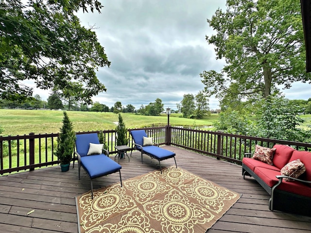 wooden deck with an outdoor hangout area and a yard