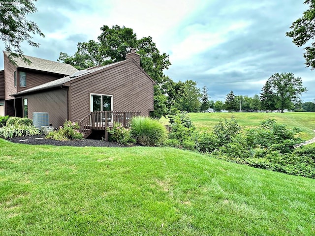 view of yard with a deck and central AC unit