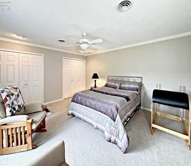 bedroom featuring ceiling fan, crown molding, a textured ceiling, and light carpet