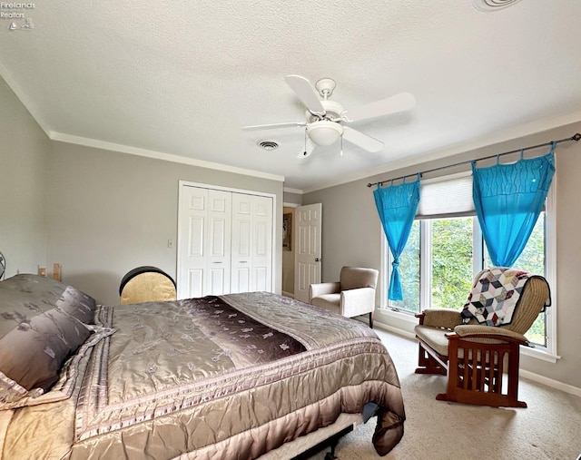 carpeted bedroom with a textured ceiling, crown molding, a closet, and ceiling fan