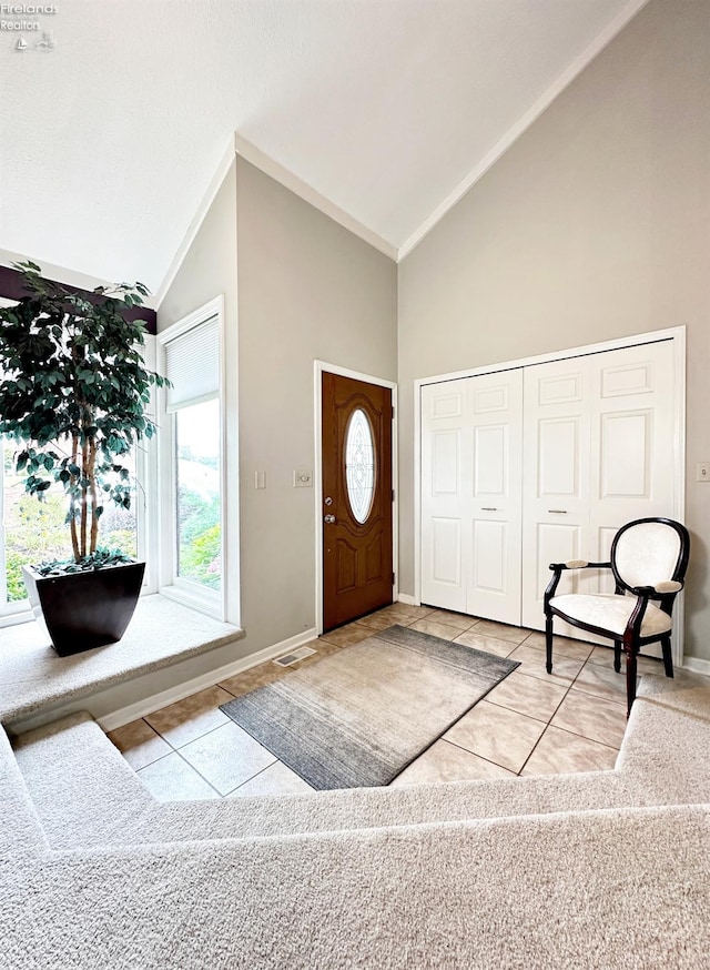 foyer featuring high vaulted ceiling and light tile patterned floors