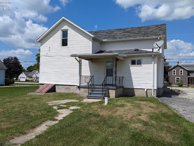 rear view of property featuring a lawn