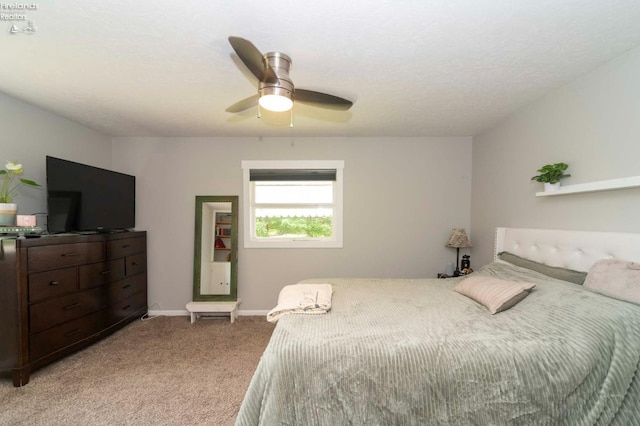 carpeted bedroom with ceiling fan and a textured ceiling