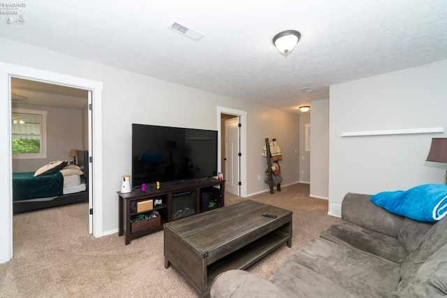 carpeted living room featuring a textured ceiling