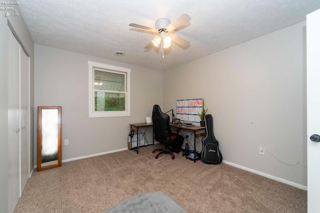 carpeted home office featuring ceiling fan and a textured ceiling