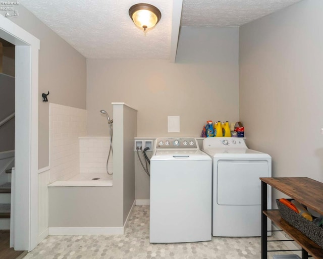 laundry room featuring a textured ceiling and separate washer and dryer