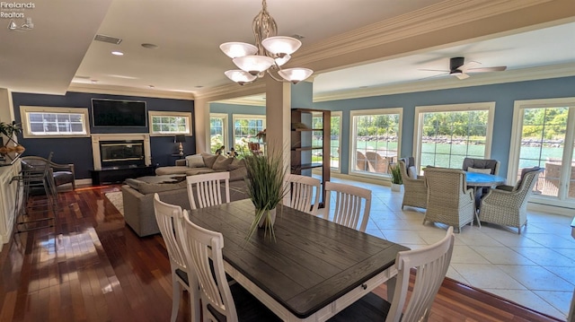 dining space with crown molding, ceiling fan with notable chandelier, and hardwood / wood-style floors