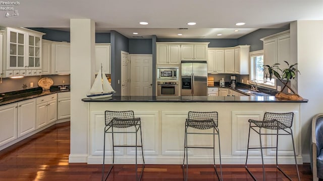 kitchen featuring white cabinetry, stainless steel appliances, and a breakfast bar