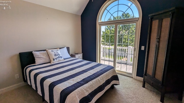 carpeted bedroom with vaulted ceiling and access to outside