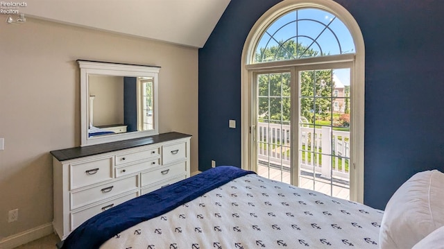 bedroom with vaulted ceiling and access to outside