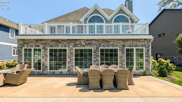 back of property featuring a balcony and a patio area