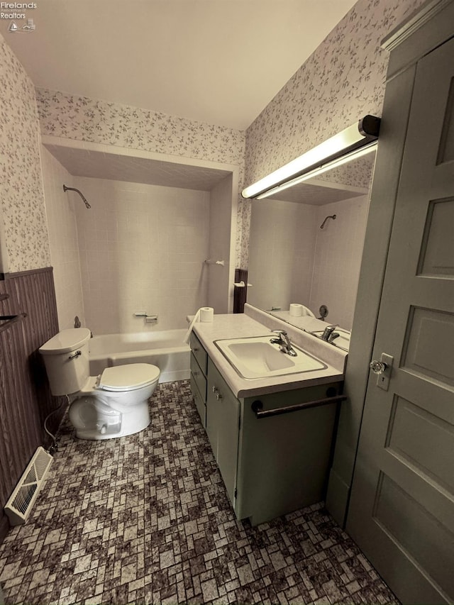 bathroom with wallpapered walls, visible vents, toilet, bathtub / shower combination, and vanity