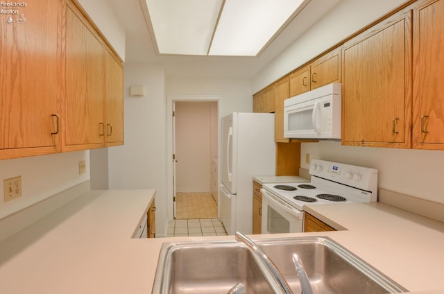 kitchen with tile patterned floors, sink, and white appliances