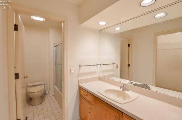 full bathroom with tile patterned floors, vanity, bath / shower combo with glass door, and toilet