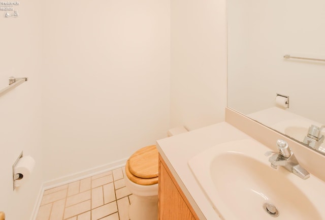 bathroom with toilet, vanity, and tile patterned floors