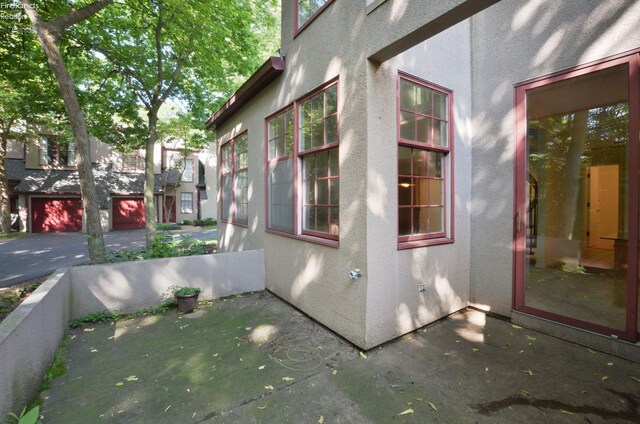 view of property exterior featuring a patio area and a garage