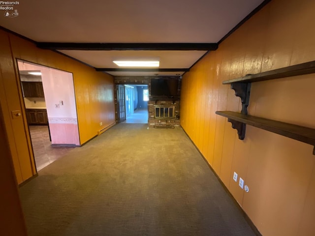 hall featuring beam ceiling, a baseboard heating unit, wooden walls, and carpet flooring