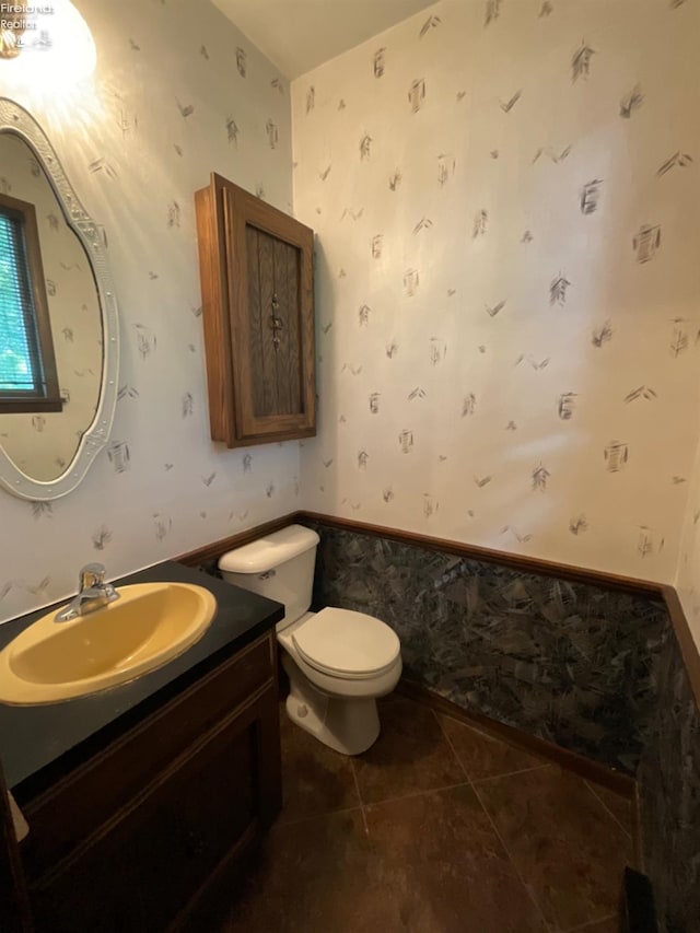 bathroom with toilet, vanity, and tile patterned floors