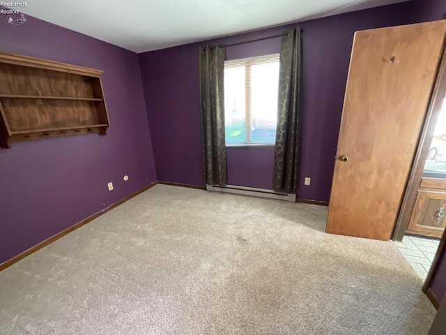 spare room with a baseboard radiator and light carpet