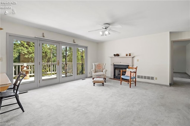 sitting room featuring ceiling fan and light carpet