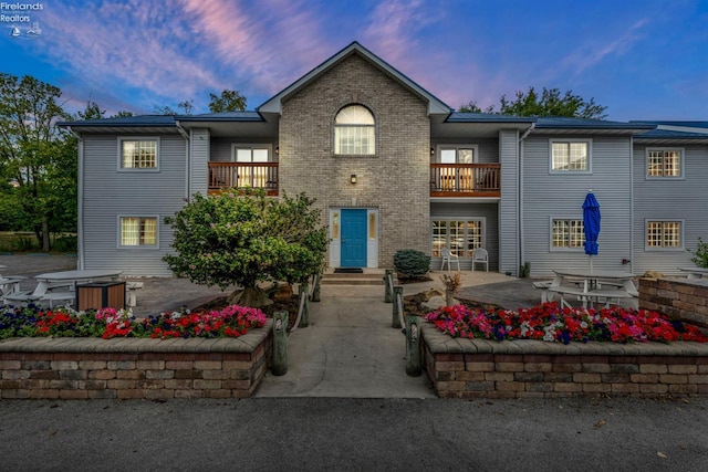 view of front of property with a balcony and a patio