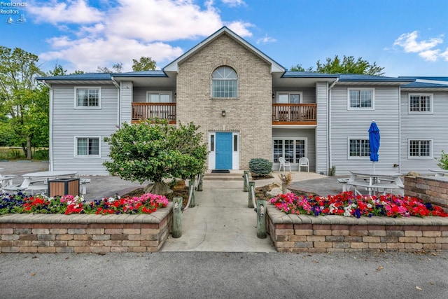 view of front of home with a patio and a balcony