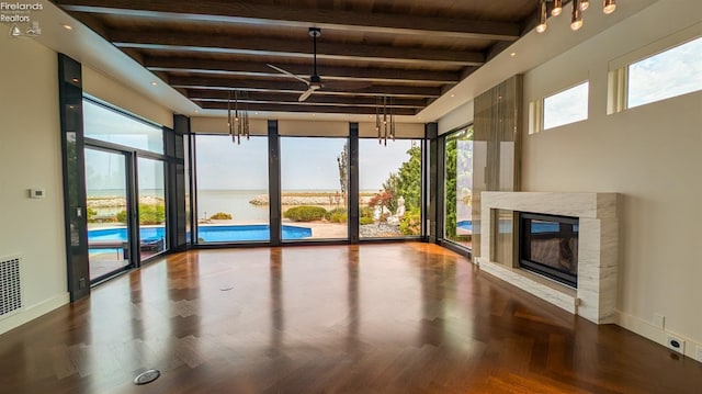 unfurnished sunroom featuring a fireplace, beam ceiling, and ceiling fan