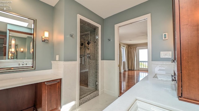 bathroom featuring vanity, wood-type flooring, and walk in shower