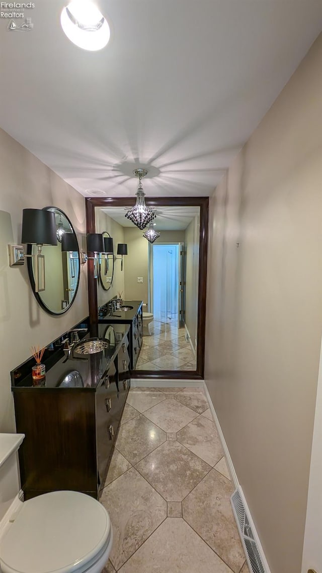 bathroom featuring tile patterned flooring, toilet, and vanity