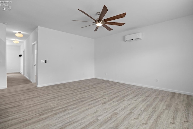 empty room featuring light wood-type flooring, ceiling fan, and an AC wall unit