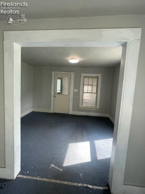 unfurnished room featuring baseboards