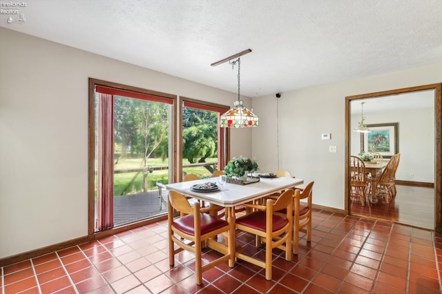 tiled dining space featuring a textured ceiling