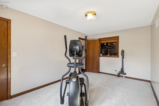 workout room featuring light carpet