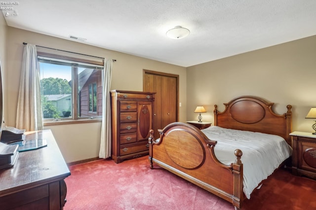 bedroom featuring a textured ceiling and carpet floors