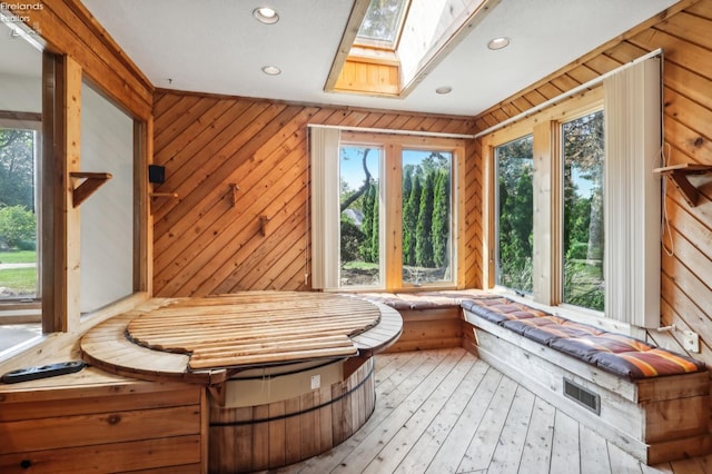 unfurnished sunroom featuring a skylight