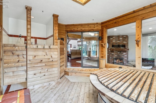 interior space featuring a fireplace, wood-type flooring, and a healthy amount of sunlight