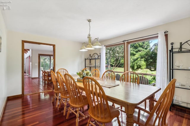 dining area with an inviting chandelier, plenty of natural light, and dark hardwood / wood-style flooring