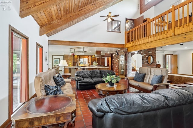 living room with tile patterned flooring, ceiling fan, high vaulted ceiling, and beam ceiling