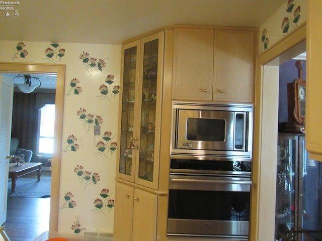 kitchen featuring appliances with stainless steel finishes, light brown cabinetry, and hardwood / wood-style floors