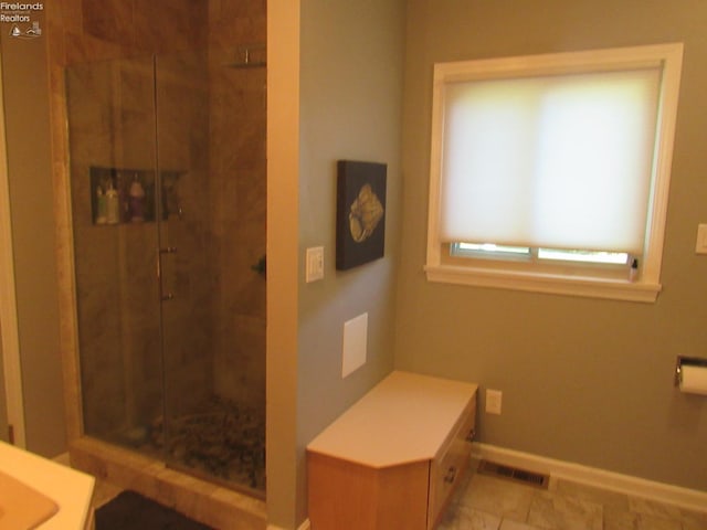 bathroom with a shower with shower door and tile patterned floors