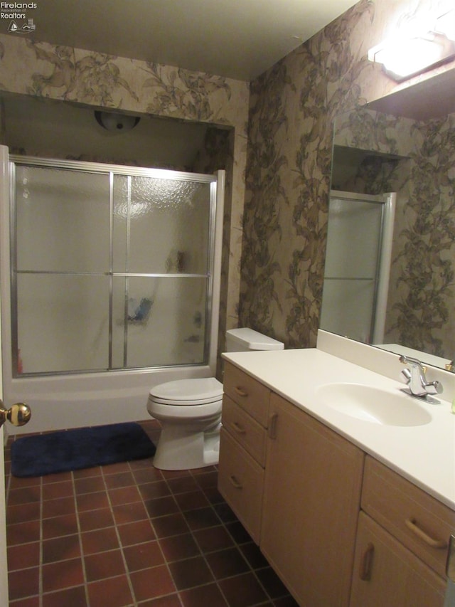 full bathroom with tile patterned flooring, vanity, toilet, and bath / shower combo with glass door