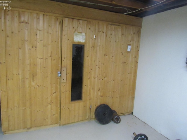 unfurnished room with concrete floors and wood walls