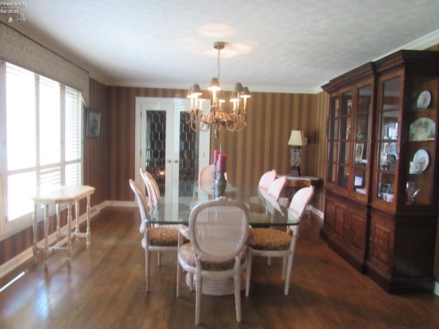 dining area with crown molding, a textured ceiling, an inviting chandelier, and dark hardwood / wood-style floors