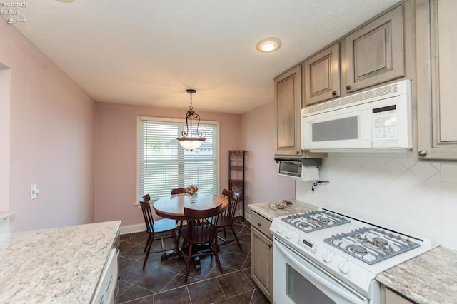 1909 N Nan Ave, Marblehead, OH 43440 - kitchen with white appliances, backsplash, dark tile patterned floors, hanging light fixtures, and baseboards