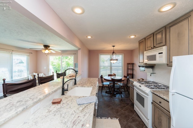 1909 N Nan Ave, Marblehead, OH 43440 - kitchen featuring white appliances, a sink, dark tile patterned floors, pendant lighting, and light stone countertops