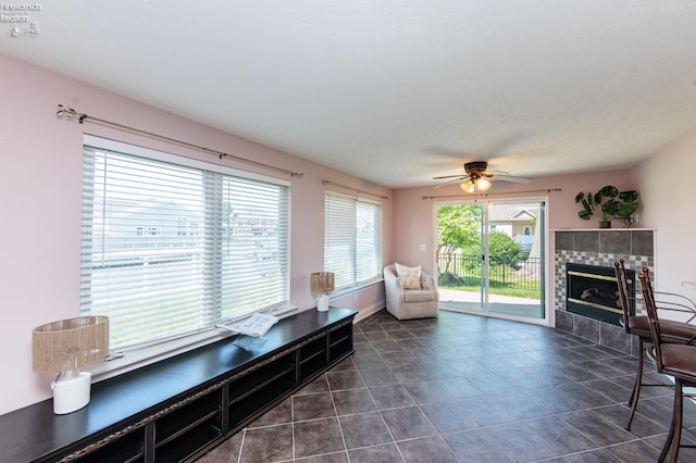 1909 N Nan Ave, Marblehead, OH 43440 - living room featuring a tiled fireplace, a ceiling fan, and dark tile patterned floors